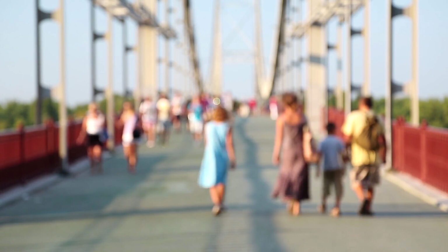 Learn how to add a blur effect to your video in premiere pro in just 4 simple steps - image of people walking across a bridge that is blurred